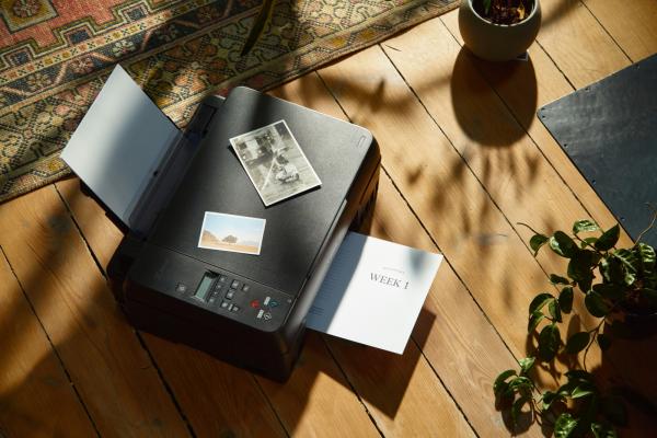Tiskárna Canon Pixma s výtiskem v zásobníku papíru.